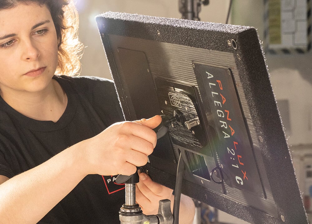 Crew member mounts Panalux Allegra on stand